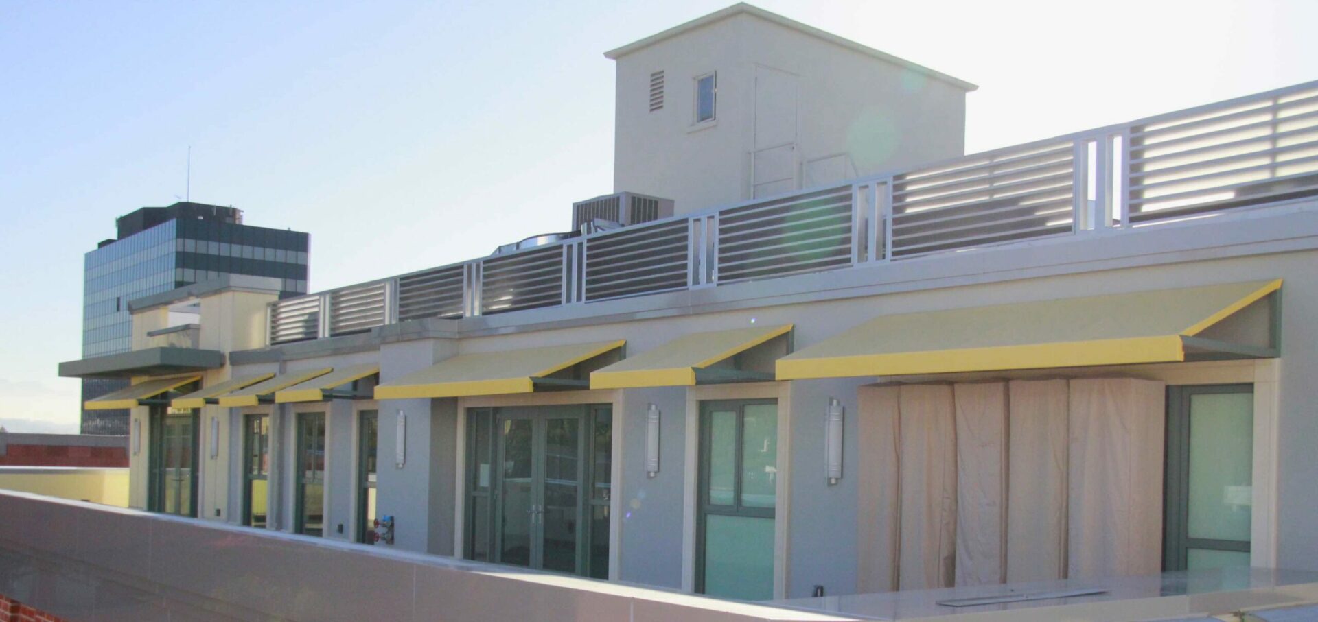 Yellow window awnings over backyard doors and windows