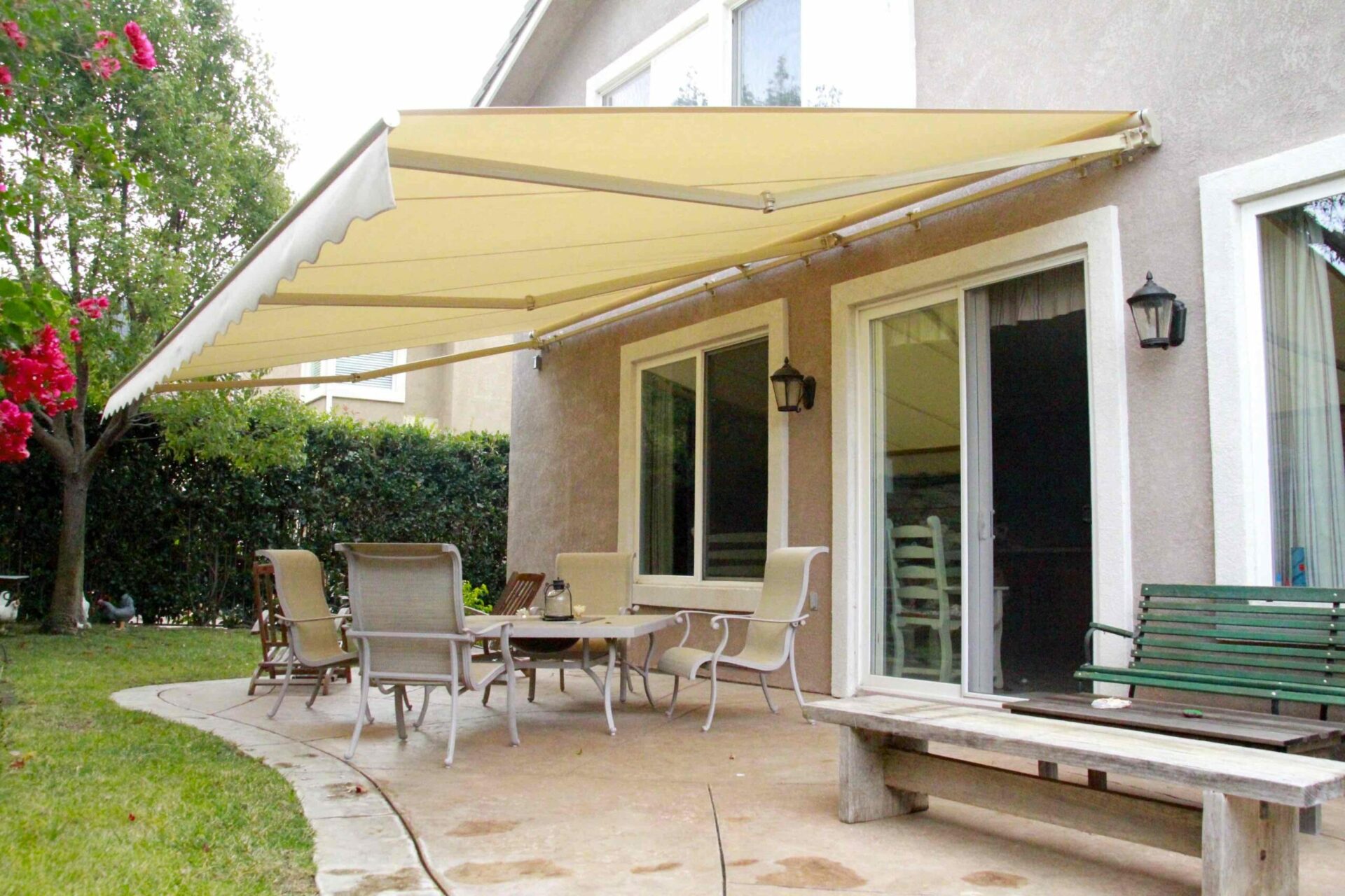 Motorized patio awnings over a backyard