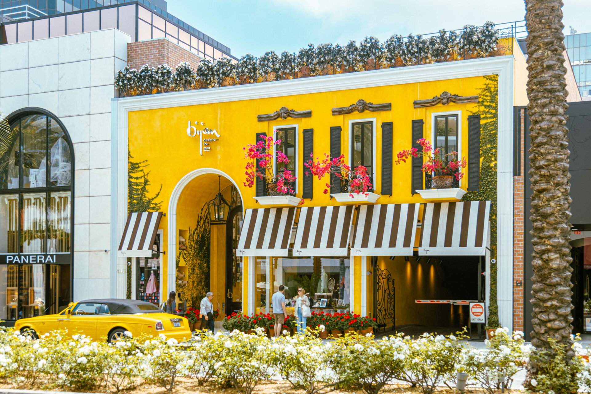 Yellow retail building with striped awning.